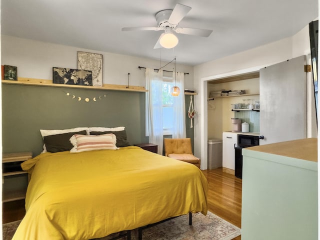 bedroom with a closet, a ceiling fan, and wood finished floors