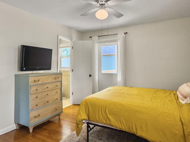 bedroom with ensuite bath, ceiling fan, and wood finished floors