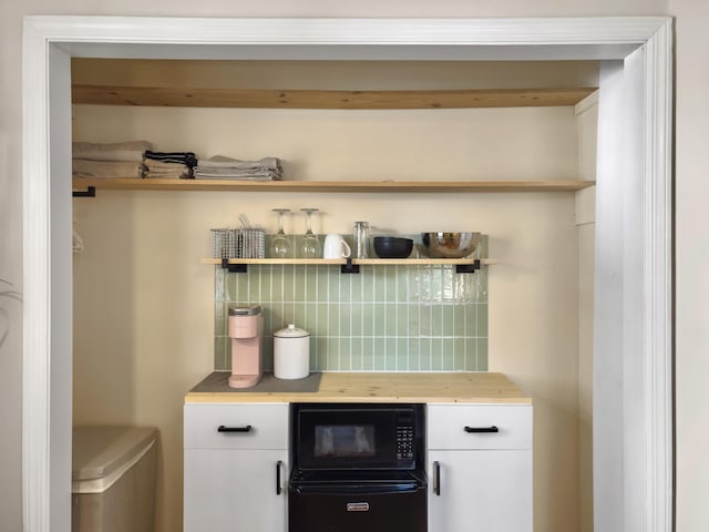 bar with tasteful backsplash and black microwave