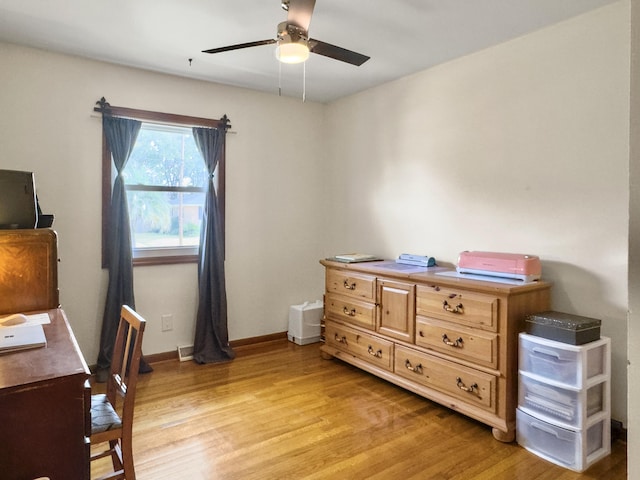 office area with baseboards, ceiling fan, and light wood-style floors