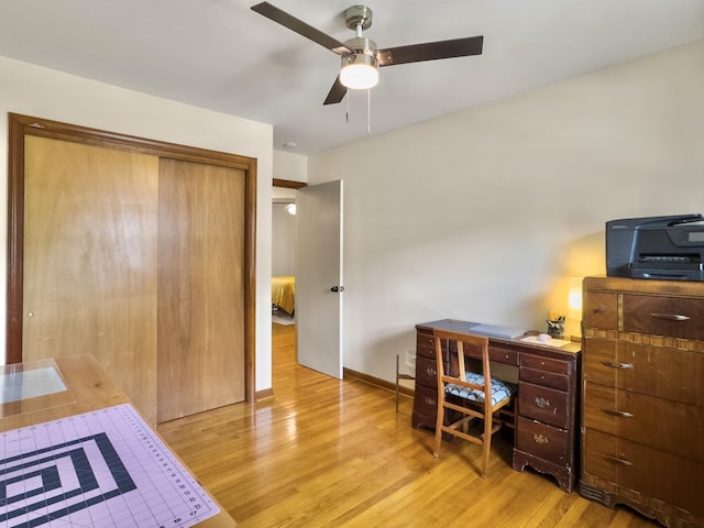 home office featuring a ceiling fan, baseboards, and light wood finished floors