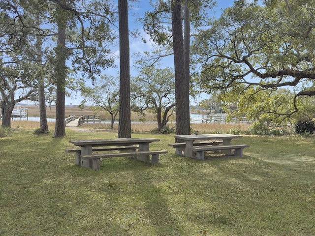 surrounding community featuring a water view and a lawn