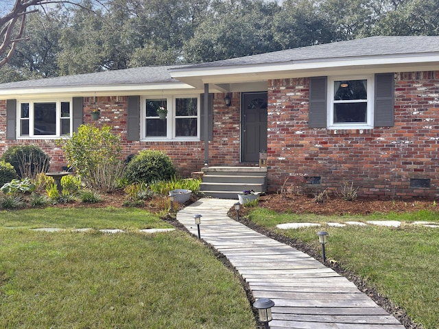 single story home with roof with shingles, brick siding, crawl space, and a front yard