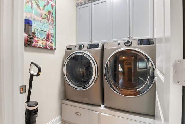 laundry area featuring cabinets and washer and clothes dryer