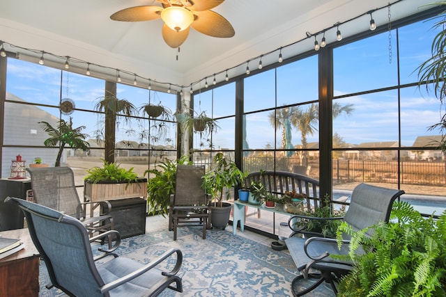 sunroom with ceiling fan, rail lighting, and a wealth of natural light