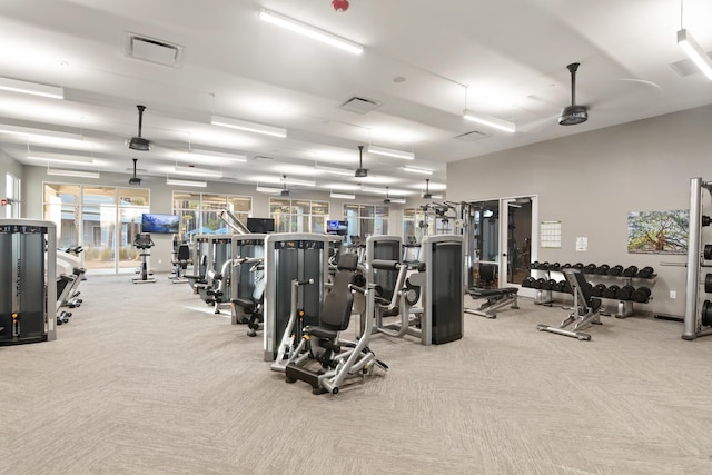 exercise room featuring light carpet and ceiling fan