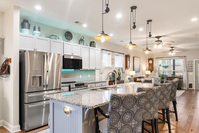 kitchen with white cabinetry, an island with sink, appliances with stainless steel finishes, and sink