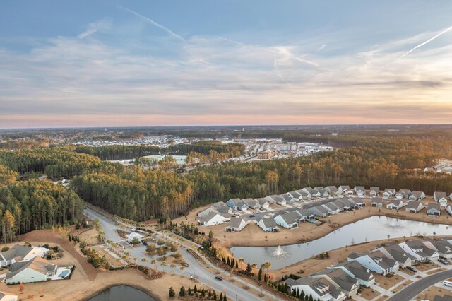 aerial view at dusk featuring a water view