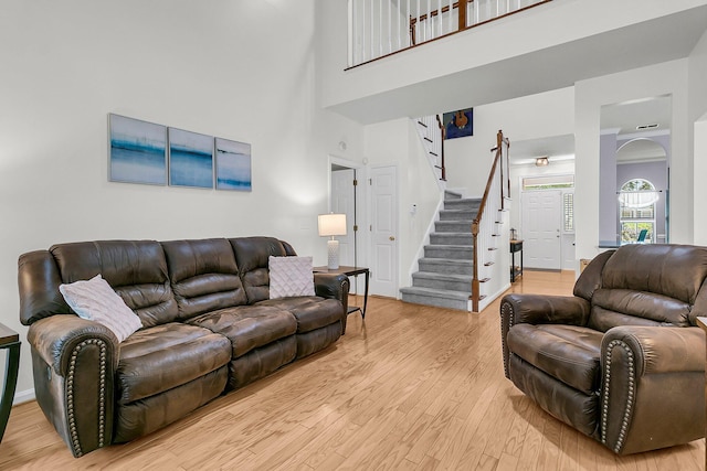 3257 Heathland Way, Mount Pleasant, SC 29466 - living room with stairway, light wood-style floors, a high ceiling, and arched walkways