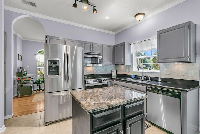 3257 Heathland Way, Mount Pleasant, SC 29466 - kitchen with stainless steel appliances, gray cabinets, arched walkways, decorative backsplash, and a center island