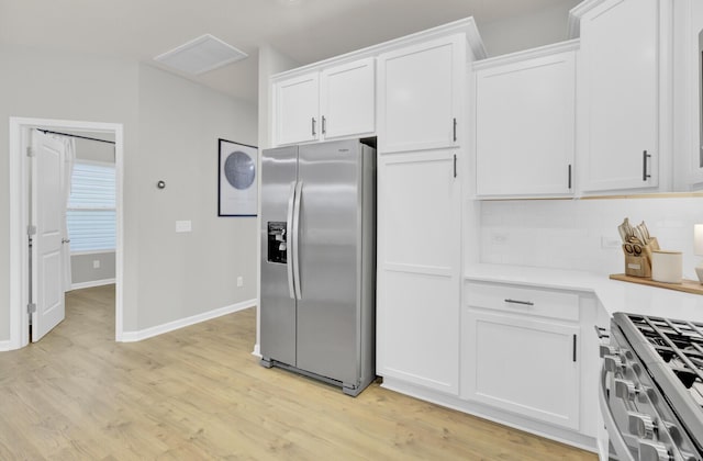 kitchen featuring white cabinetry, appliances with stainless steel finishes, decorative backsplash, and light wood-type flooring