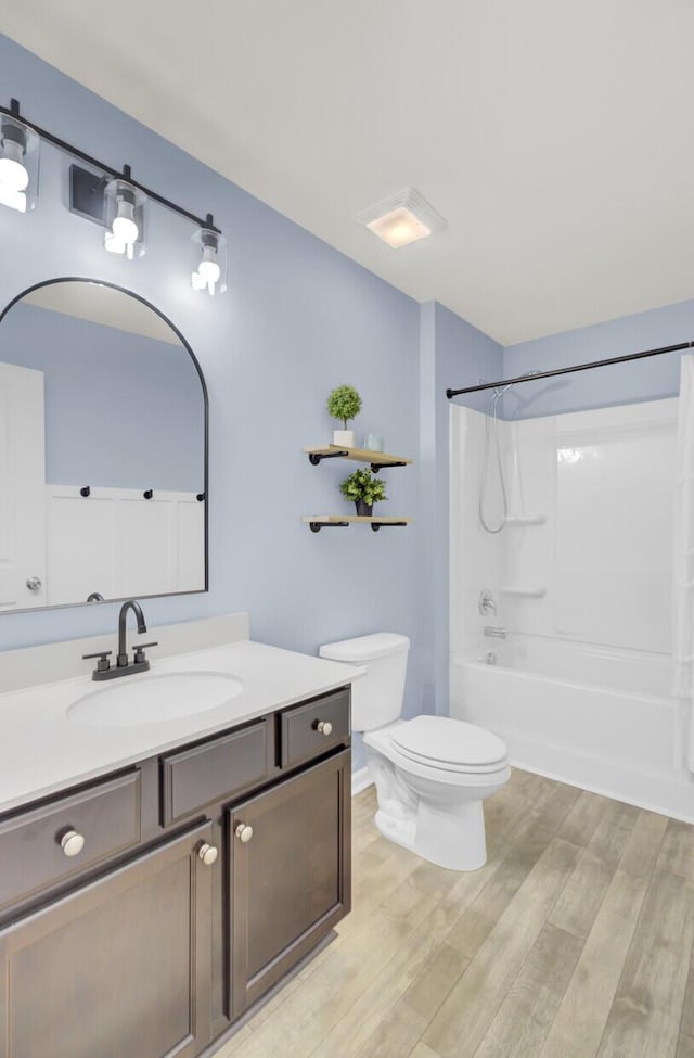 full bathroom with vanity, wood-type flooring, shower / washtub combination, and toilet