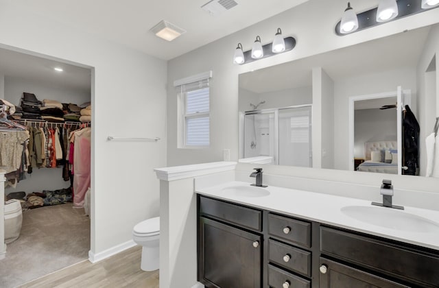 bathroom featuring hardwood / wood-style flooring, vanity, toilet, and an enclosed shower