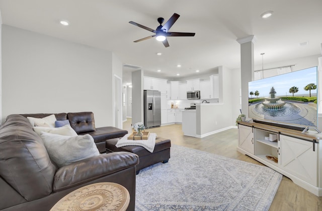 living room with ceiling fan and light wood-type flooring