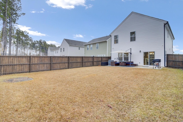 rear view of house with central AC, a patio, and a lawn