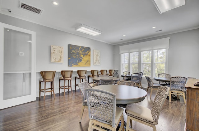 dining room with dark wood-type flooring and ornamental molding