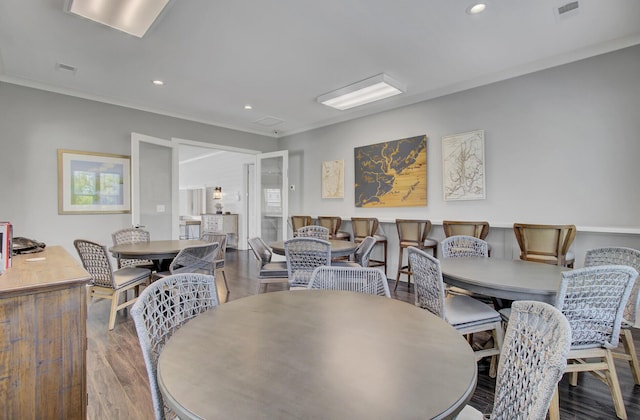 dining area featuring hardwood / wood-style flooring and ornamental molding