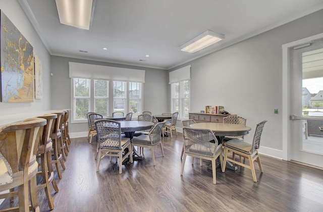 dining space with hardwood / wood-style flooring, a wealth of natural light, and ornamental molding