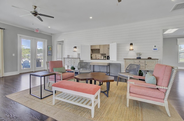 living room featuring ceiling fan, plenty of natural light, ornamental molding, and light hardwood / wood-style floors