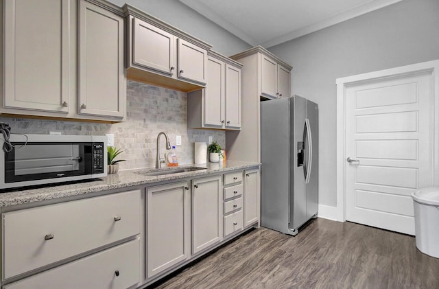 kitchen featuring stainless steel refrigerator with ice dispenser, sink, light stone counters, dark hardwood / wood-style floors, and decorative backsplash