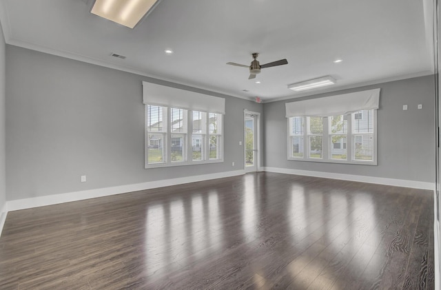 spare room with crown molding, plenty of natural light, and dark wood-type flooring