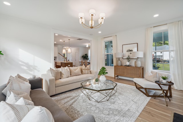 living room featuring a chandelier, recessed lighting, light wood-style floors, and ornamental molding