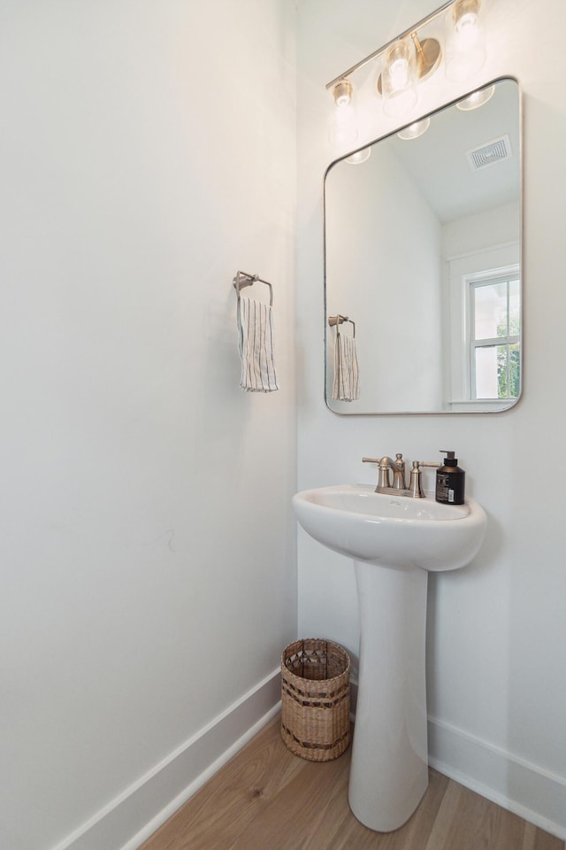 bathroom featuring visible vents, baseboards, and wood finished floors