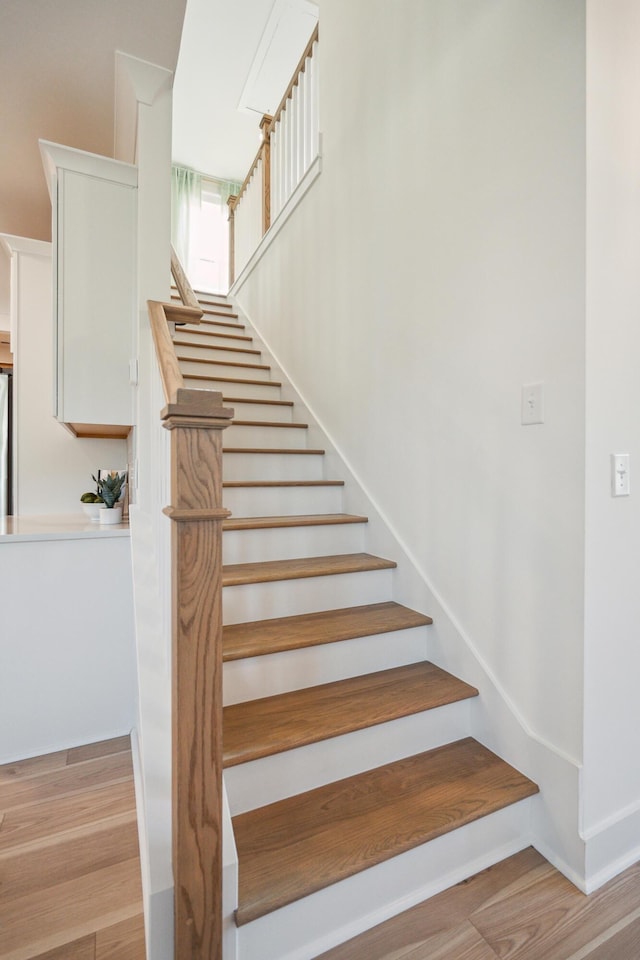 stairs with wood finished floors and baseboards