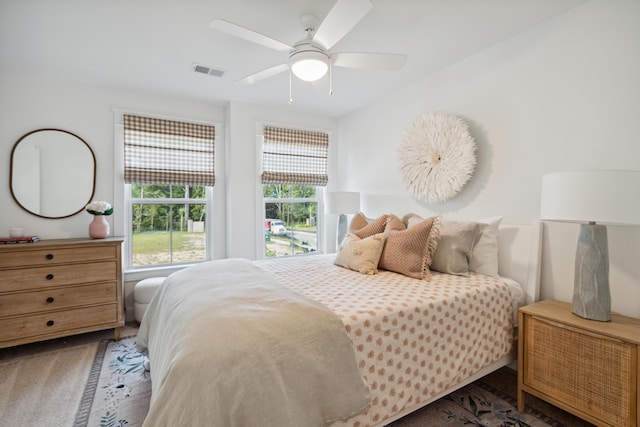 carpeted bedroom with a ceiling fan and visible vents