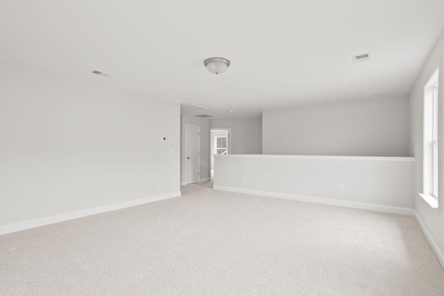 carpeted spare room featuring plenty of natural light