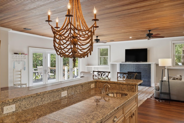 2218 Myrtle Ave, Sullivans Island, SC 29482 - kitchen with ceiling fan, a tile fireplace, open floor plan, light stone counters, and ornamental molding