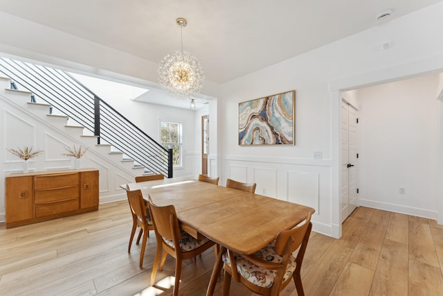 dining area featuring an inviting chandelier and light hardwood / wood-style flooring