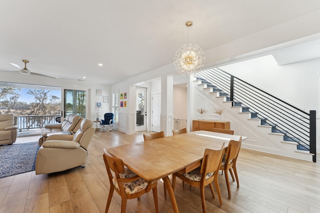 dining space featuring ceiling fan with notable chandelier and light hardwood / wood-style floors