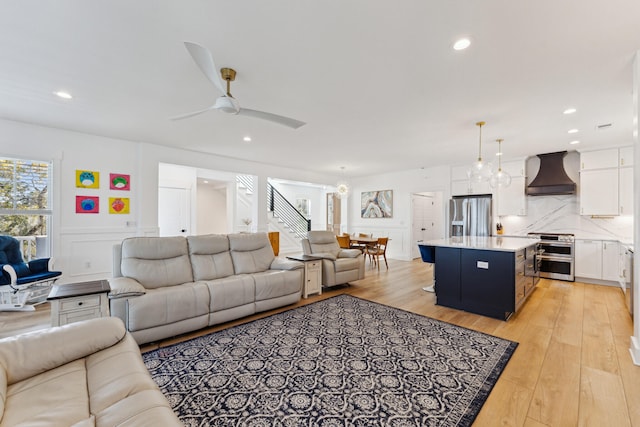 living room with ceiling fan and light hardwood / wood-style flooring