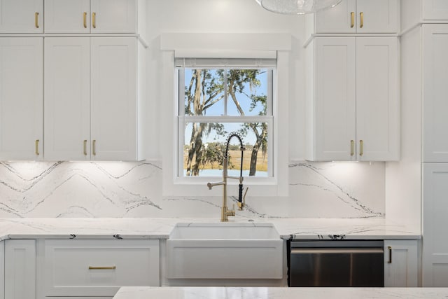 kitchen with white cabinetry, stainless steel dishwasher, and light stone counters