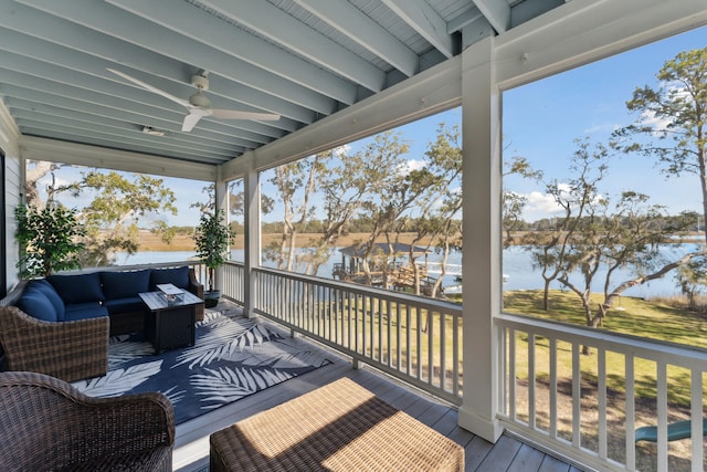 wooden deck featuring an outdoor living space with a fire pit, ceiling fan, and a water view