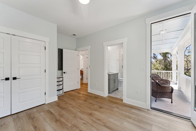 unfurnished bedroom with ensuite bathroom, sink, light wood-type flooring, access to outside, and a closet