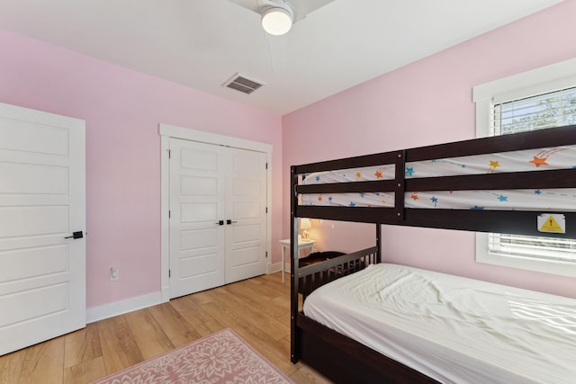 bedroom with light hardwood / wood-style floors and a closet