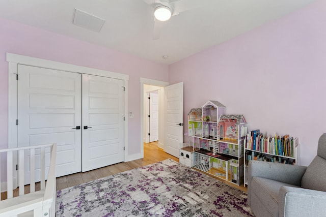 bedroom with light hardwood / wood-style floors, a closet, and ceiling fan