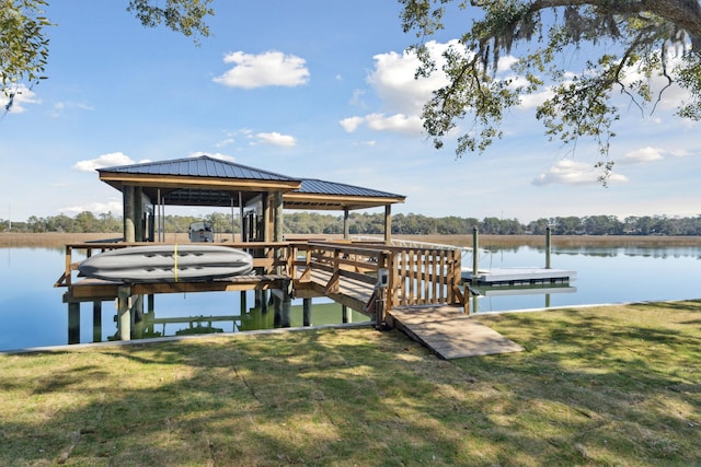 view of dock with a water view and a lawn