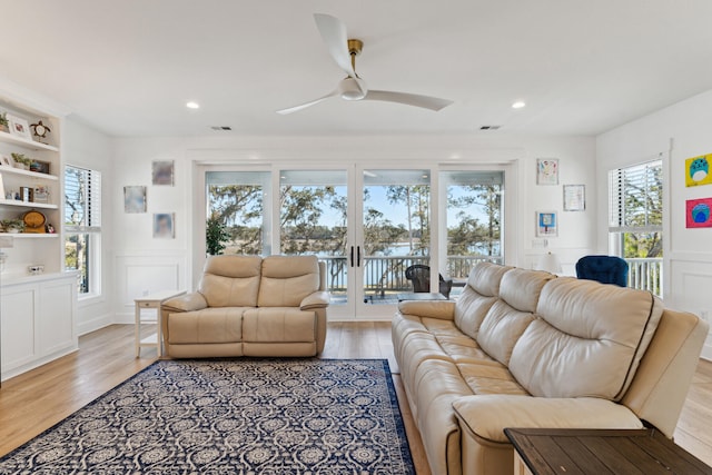 living room featuring french doors, ceiling fan, and light wood-type flooring