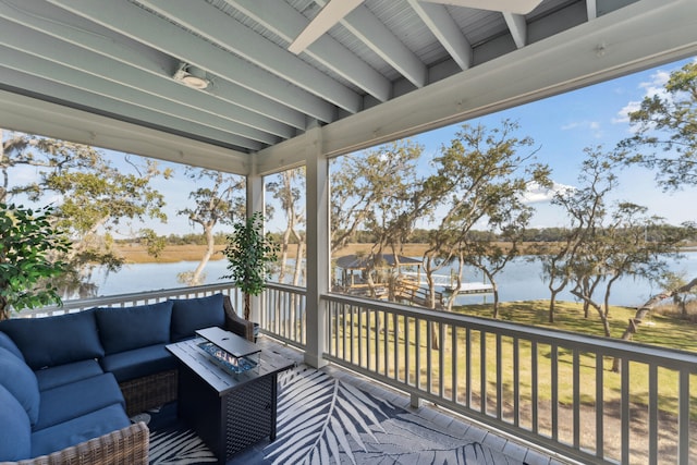 wooden terrace featuring an outdoor living space and a water view