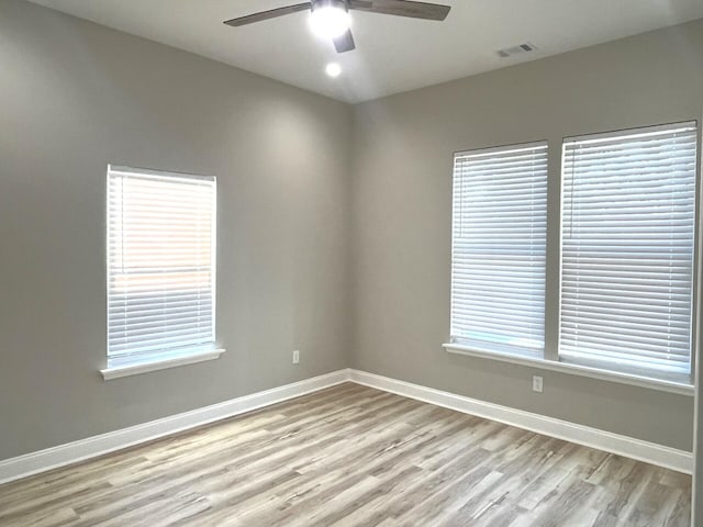 spare room with ceiling fan and light wood-type flooring