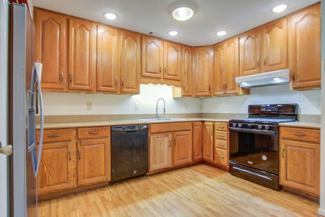 kitchen with black appliances, light hardwood / wood-style flooring, and sink