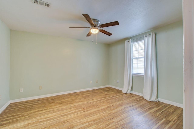 empty room featuring ceiling fan and light hardwood / wood-style flooring