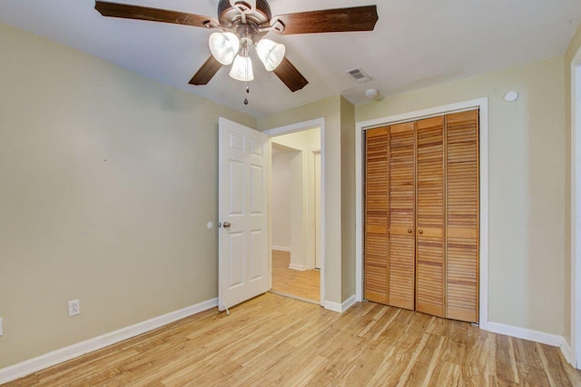 unfurnished bedroom with ceiling fan, a closet, and light hardwood / wood-style floors