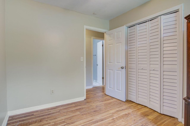 unfurnished bedroom featuring light hardwood / wood-style floors and a closet