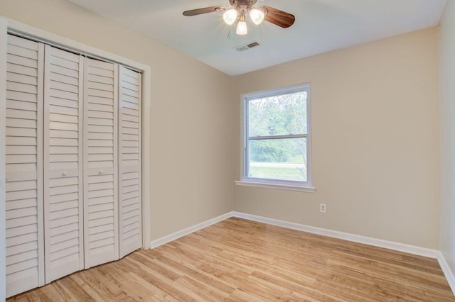 unfurnished bedroom featuring ceiling fan, light hardwood / wood-style flooring, and a closet