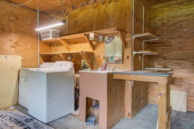 clothes washing area featuring independent washer and dryer and wooden walls