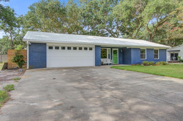 single story home featuring a garage and a front yard